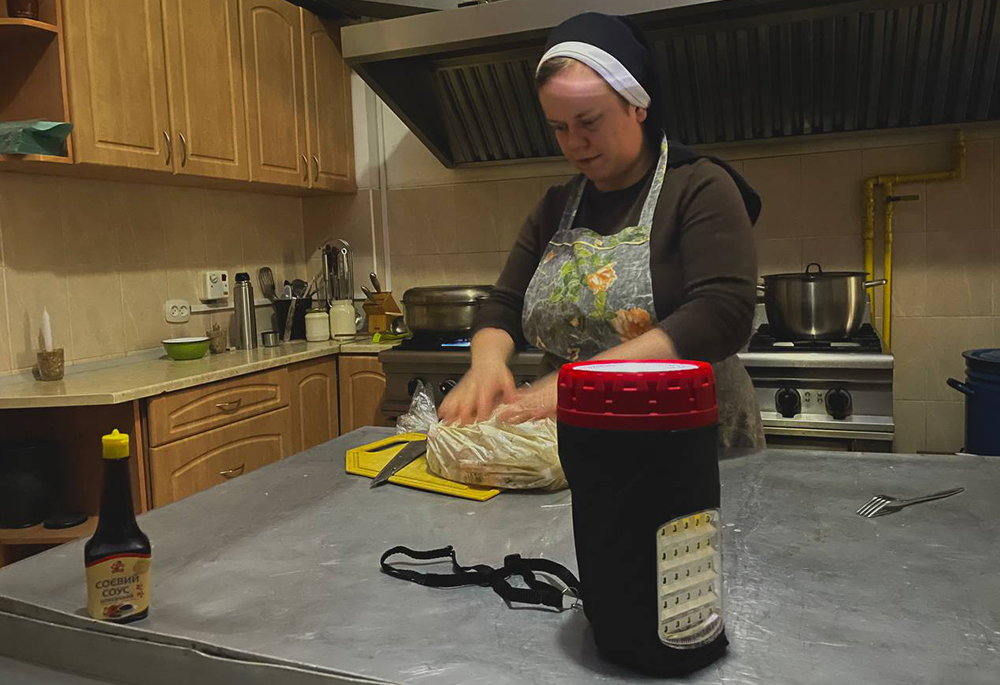 A Basilian sister prepares food by lantern in Ukraine. (Courtesy of Yeremiya Steblyna)