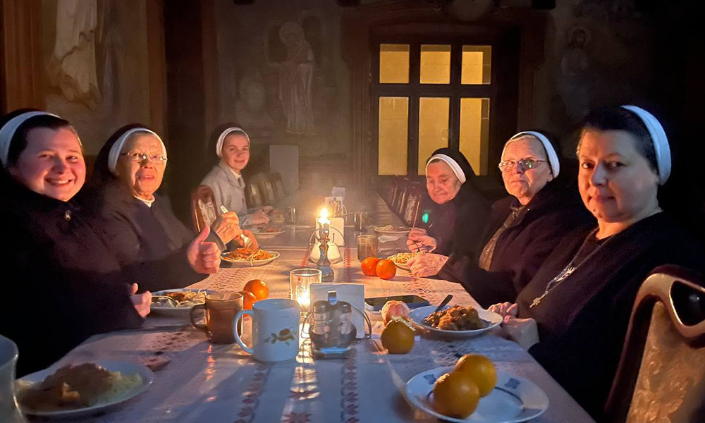 Basilian sisters in Ukraine eat a dinner lit by candles. (Courtesy of Yeremiya Steblyna)
