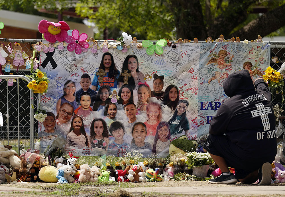 A mourner stops to pay his respects at a memorial at Robb Elementary School June 9 in Uvalde, Texas. The memorial was created to honor the two teachers and 19 students killed in a mass shooting at the school on May 24. (AP/Eric Gay, File)