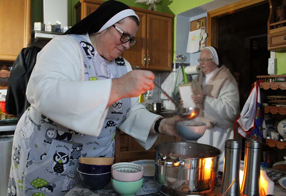 Sr. Mateusza Trynda, the local superior of the Dominican convent and a resident of Zhovkva, Ukraine, for 28 years, serves soup for guests during a midday candlelit meal Nov. 24. (GSR photo/Chris Herlinger)