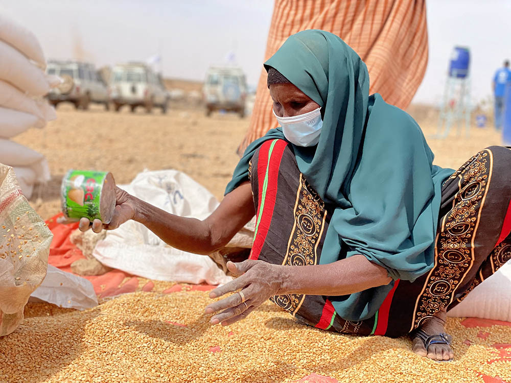 A woman collects grain Jan. 22 at a camp for internally displaced people in Adadle in the Somali Region of Ethiopia. (CNS/Reuters/Courtesy of the World Food Program/Claire Nevill)