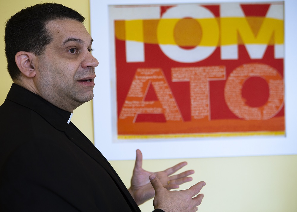 Sulpician Fr. Dominic Ciriaco, rector of Theological College in Washington, points to a serigraph by Corita Kent.