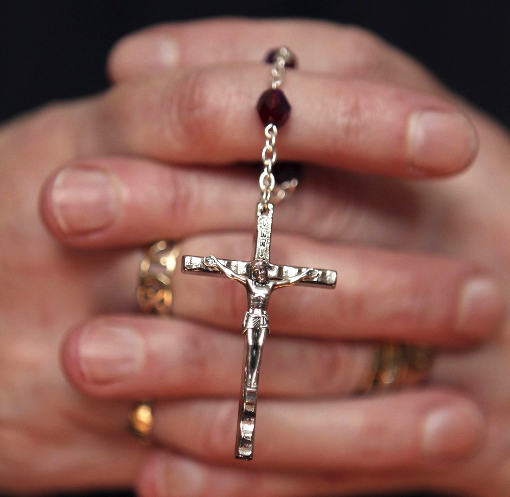 A woman holds a rosary during a March 21, 2010, Mass at a church in Armagh, Northern Ireland. (CNS/Reuters/Cathal McNaughton)