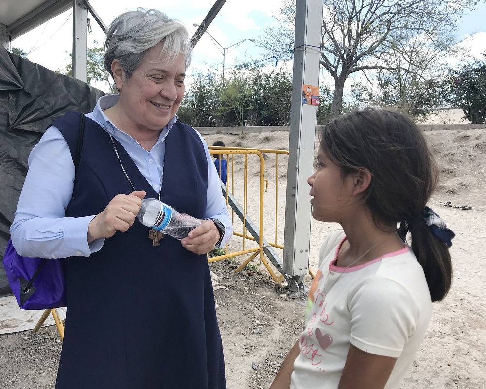 Sr. Norma Pimentel, director of Catholic Charities of the Rio Grande Valley in Texas, speaks with a young resident of a tent camp Feb. 29, 2020, in Matamoros, Mexico. (CNS/David Agren)