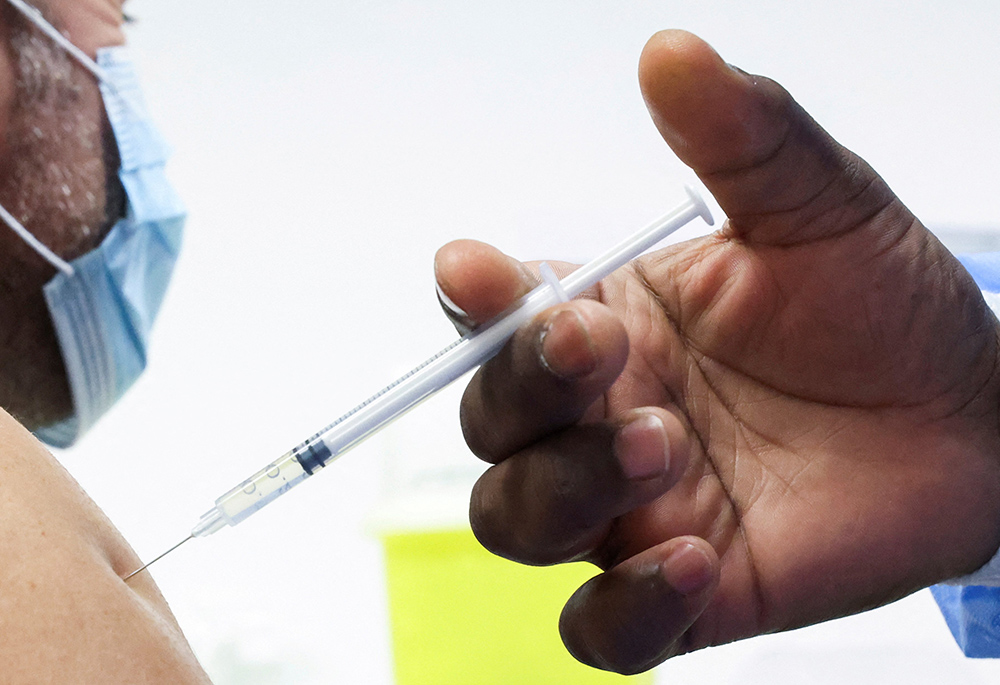 A man receives a booster dose of Pfizer's COVID-19 vaccine in this undated photo. (CNS/Reuters/Yves Herman)