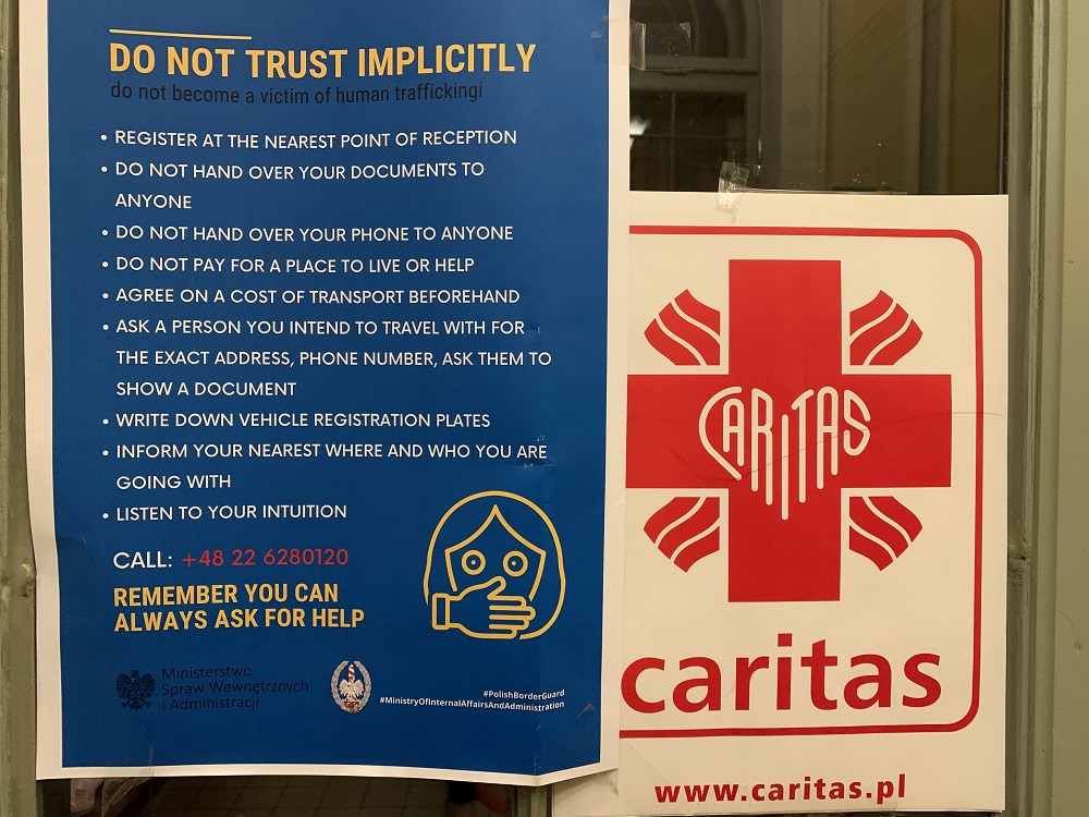 A sign on the office of Caritas at the train station in the Polish border town of Przemysl instructs Ukrainian refugees, especially women, on how to avoid becoming victims of trafficking or falling into the clutches of unscrupulous people.