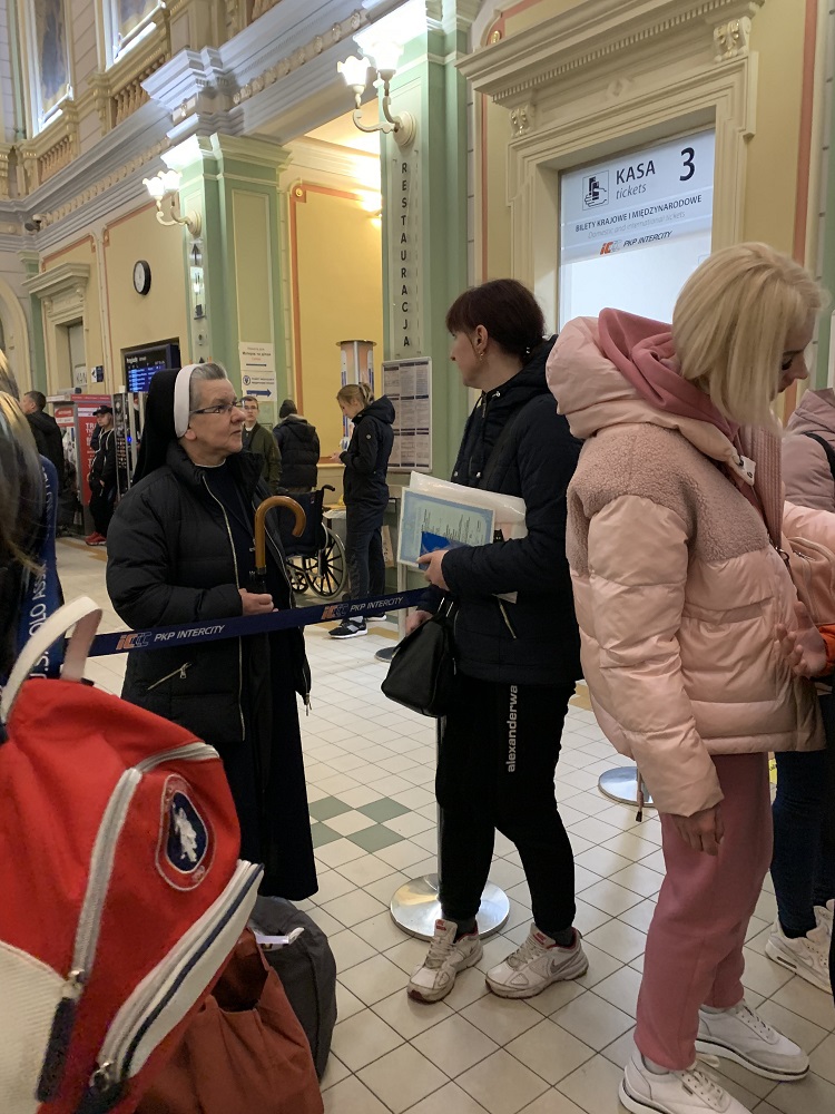 Sr. Lucja Kwasniak, a member of the Sisters, Servants of the Immaculate Heart of Mary, talks to Ukrainian refugees April 21 at the train station in Przemysl, Poland.