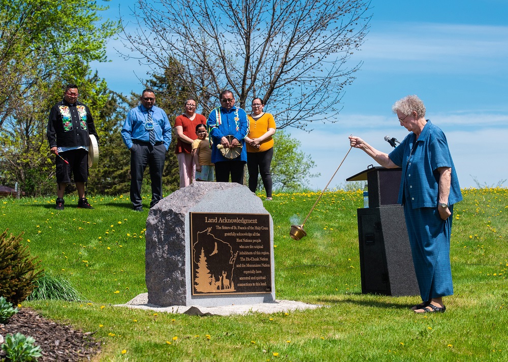 Sr. Ann Rehrauer, community president of the Sisters of St. Francis of the Holy Cross in Green Bay, Wisconsin, uses a censer May 14 to bless a monument with a plaque that acknowledges "the First Nations people who are the original inhabitants of this regi