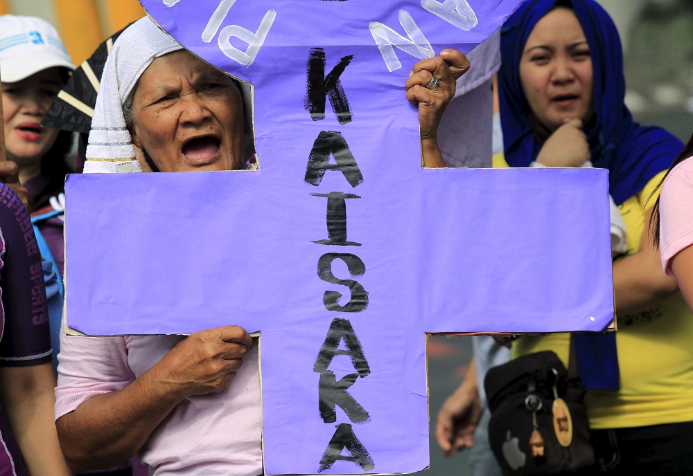 An activist holding a placard shouts anti-government slogans while protesting outside the presidential palace in Manila on March 8, 2016. In a statement on July 17, 2022, the religious superiors in the Philippines said "red-tagging" would not deter them f