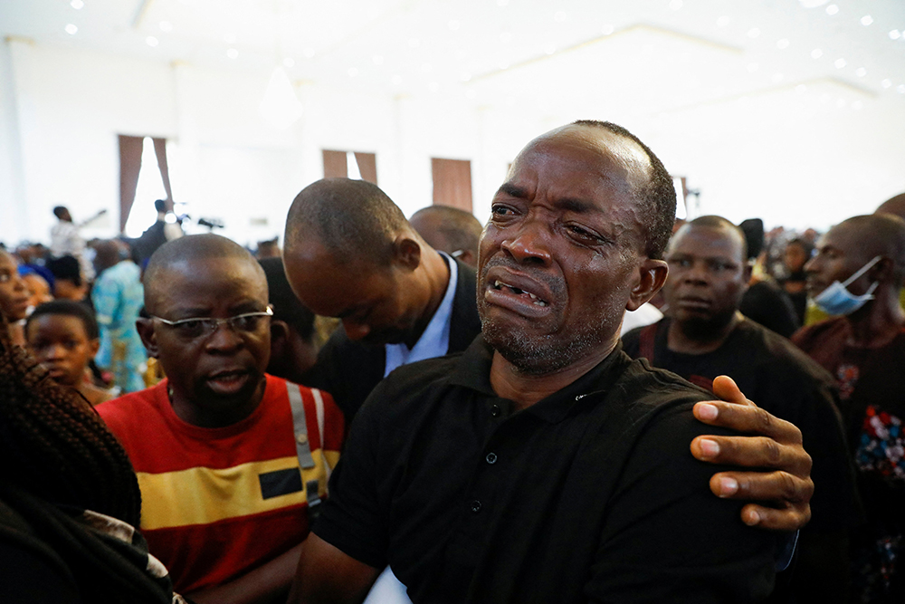 A man cries during a funeral Mass on June 17 in the parish hall of St. Francis Xavier Church in Owo, Nigeria. The Mass was for some of the 40 victims killed in a June 5 attack by gunmen during Mass at the church. (CNS/Reuters/Temilade Adelaja)