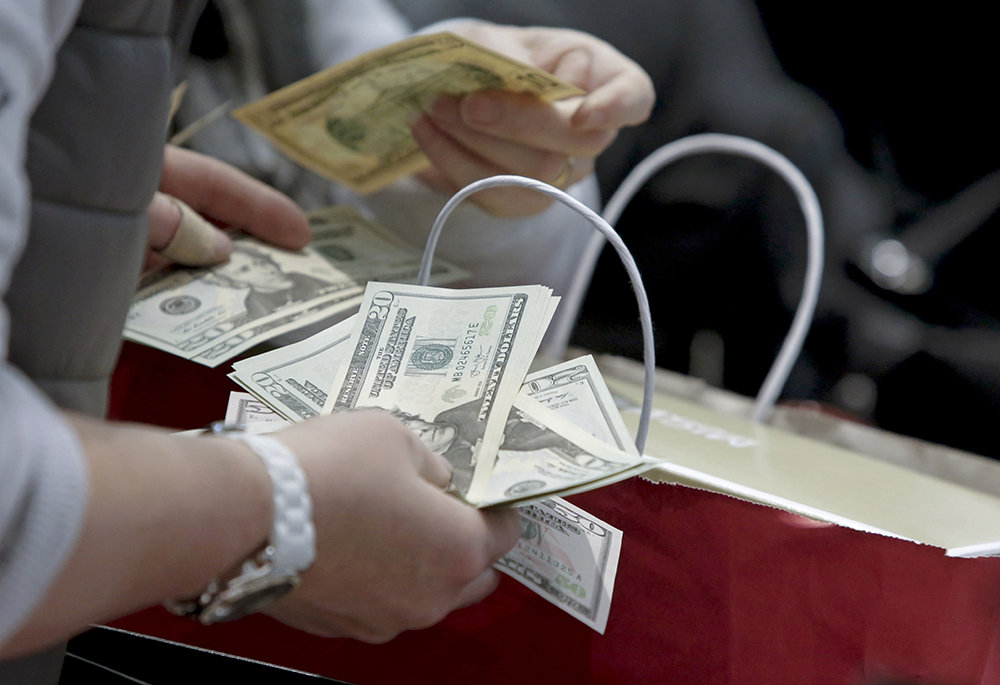 People count money in this undated photo. (CNS/Reuters/Andrew Kelly)