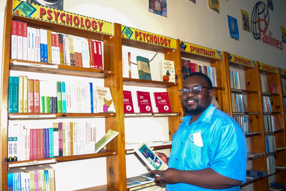 Man holds book in bookstore.