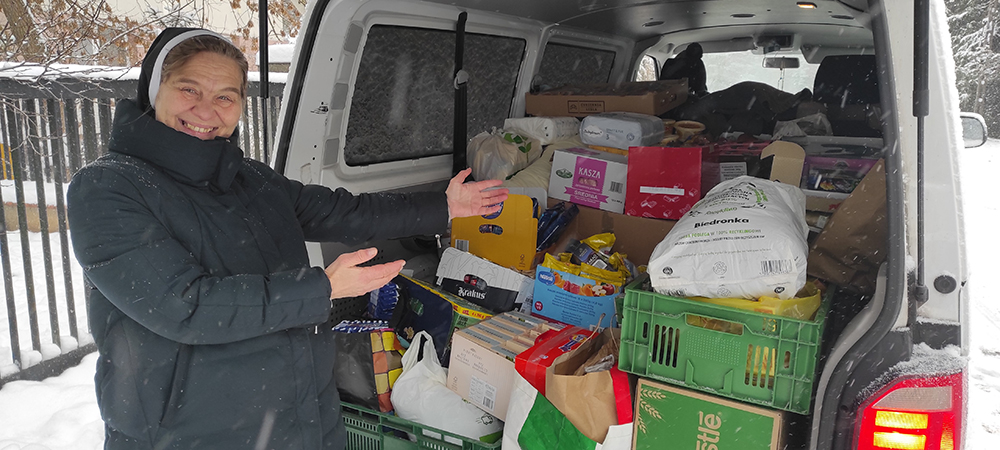 Polish Sr. Renata Jurczak gestures to a van full of supplies in the snow