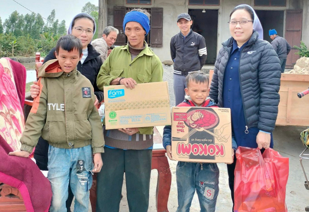 Missionaries of Charity Srs. Lucia Vu Thi Quynh Trang, right, and Maria Nguyen Thi Gia Phuoc give Tet food to farmers in Ha Tinh province in Vietnam. (Courtesy of Sr. Lucia Vu Thi Quynh Trang)