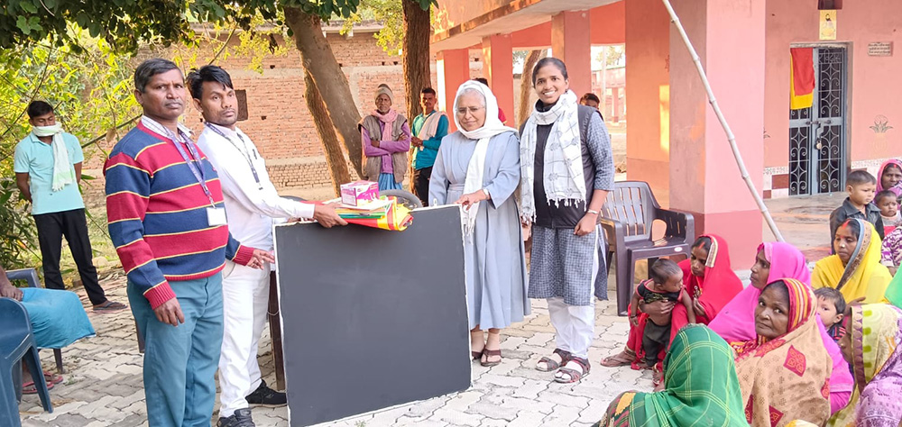Sr. Shanthi Vincent of Congregatio Jesu (at right, standing) attends a village meeting in the eastern Indian state of Bihar. Vincent said her idea of social work changed from "charity to empowerment" after her master's program at Nirmala Niketan. (Courtesy of Shanthi Vincent)