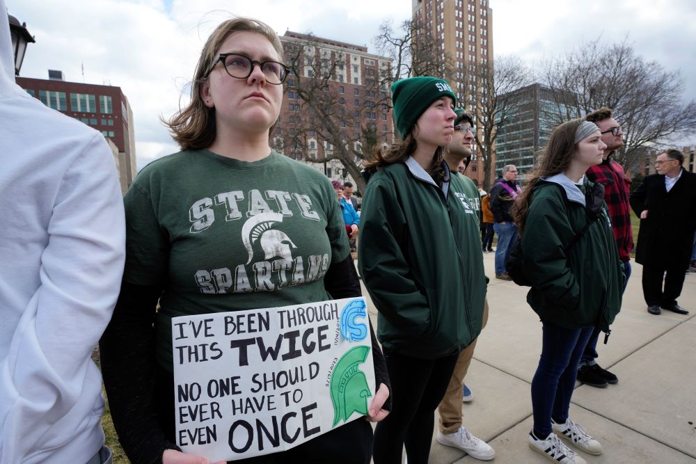 : Katie Denzin, who attended Saugus High School in California, holds a sign with current and former Michigan State University students during a Feb. 15 rally at the capitol in Lansing, Michigan. A gunman killed three students and critically injured five others Feb. 13 on Michigan State University's campus.