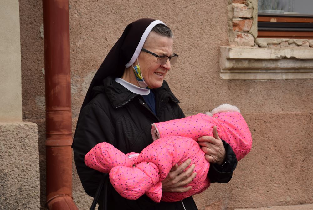 Nun holds baby.