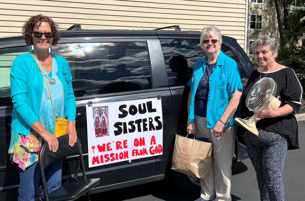 Kathy Shannon, left, who uses her van to help transport donated furniture, poses with Sr. Francis Margaret Maag, center, and Geri Herbst outside Speers Court Apartments in Dayton, Kentucky, in October 2022. (Courtesy of Francis Margaret Maag)