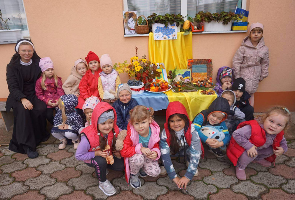 Basilian Sr. Viktoriia Estera Kozun with the kids of the kindergarten group "Bee" at the Perechyn mission station of Pope St. Clement, Transcarpathia region, present the exhibition "Gifts of Autumn" on Sept. 29, 2022. (Courtesy of Sisters of the Order of St. Basil the Great)