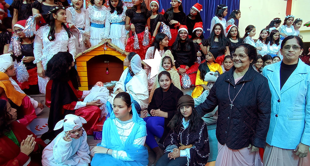 Ursuline Sr. Tisy Jose (second from right) and Sr. Ranjana Thomas (right), principal of Mariampur School in Kanpur, India, celebrate with students Christmas as the festival of life on Dec. 22, 2022. (Courtesy of Tisy Jose)
