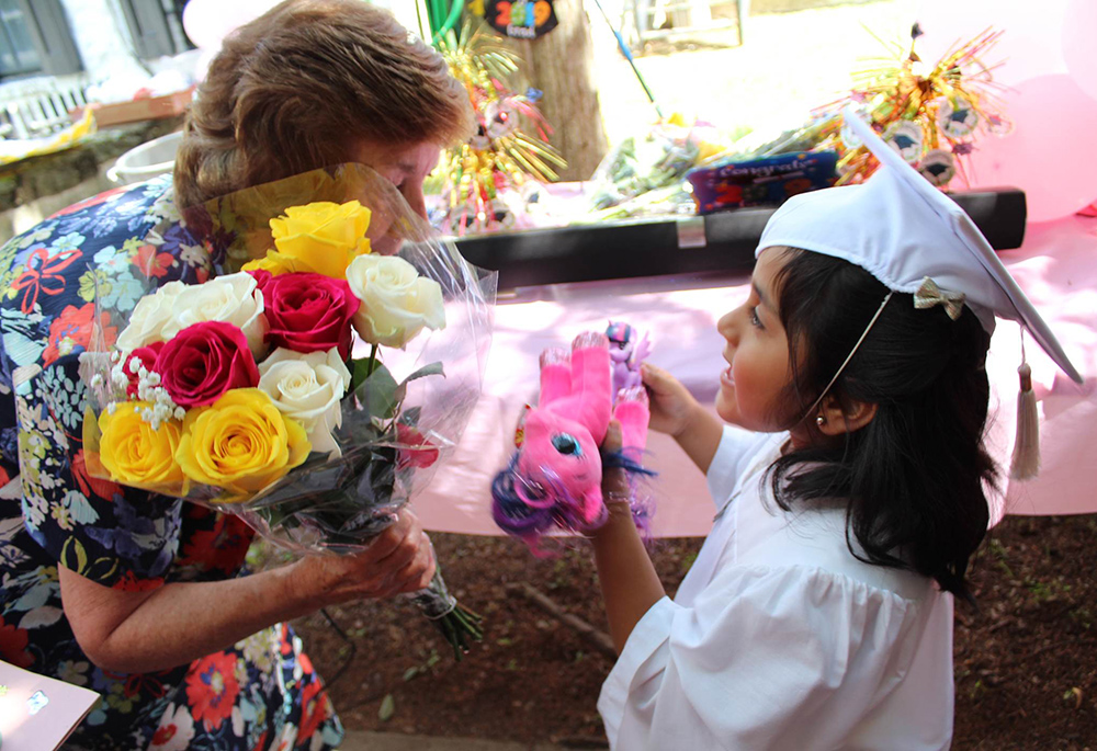 Dominican Sr. Jean Graffweg gives flowers to a House on the Hill student at their 2019 graduation ceremony. The facility in Goshen, New York, hosts a Head Start program that serves about 45 children ages 2 months to 5 years old. (Courtesy of Sisters of St. Dominic of Blauvelt, New York)