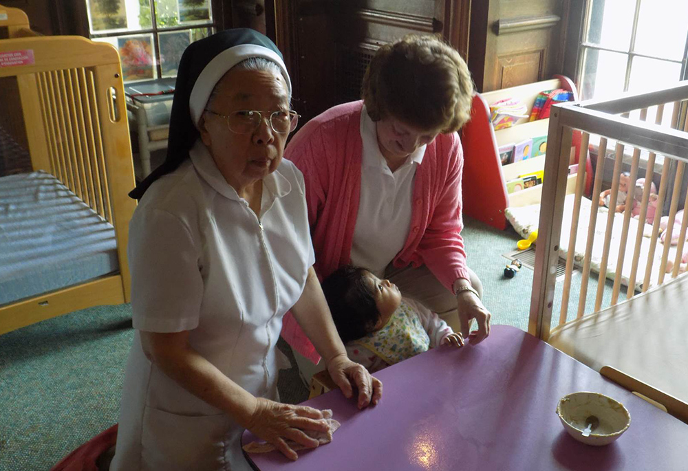 Dominican Srs. Jean Graffweg, right, and Caritas Wong are pictured with a baby in this undated photo taken at House on the Hill. When Graffweg started working there, she was one of five Dominican sisters there. She is now the only sister on staff. (Courtesy of Sisters of St. Dominic of Blauvelt, New York)