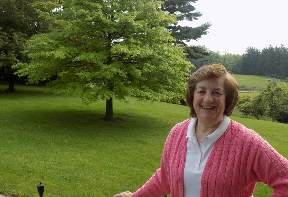 Dominican Sr. Jean Graffweg is pictured in front of the fields at House on the Hill in Goshen, New York, where she directs the Head Start program serving children of migrant farmworkers. Her community started House on the Hill after observing young children playing in the fields while their parents worked. (Courtesy of Sisters of St. Dominic of Blauvelt, New York)