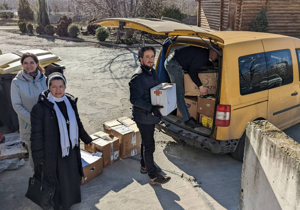 En Kiev, la Hna. Yanuariya Isyk y unos voluntarios cargan alimentos y suministros médicos destinados a Bucha (Ucrania) en una furgoneta en Kiev, en mayo.