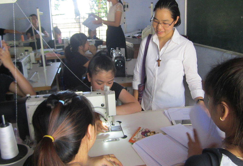 Filles de Marie Immaculée Sr. Mary Nguyen Thi Hang meets women who learn sewing skills in Hue. (GSR photo/Joachim Pham) 