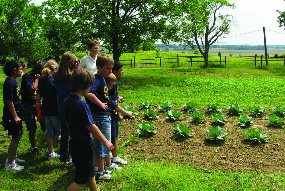 Ursuline Sr. Amelia Stenger teaches students from Sts. Peter and Paul School in Hopkinsville, Kentucky, about growing a garden sustainably on the grounds of the Mount St. Joseph motherhouse in Daviess County. (Courtesy of Ursuline Sisters of Mount St. Joseph)