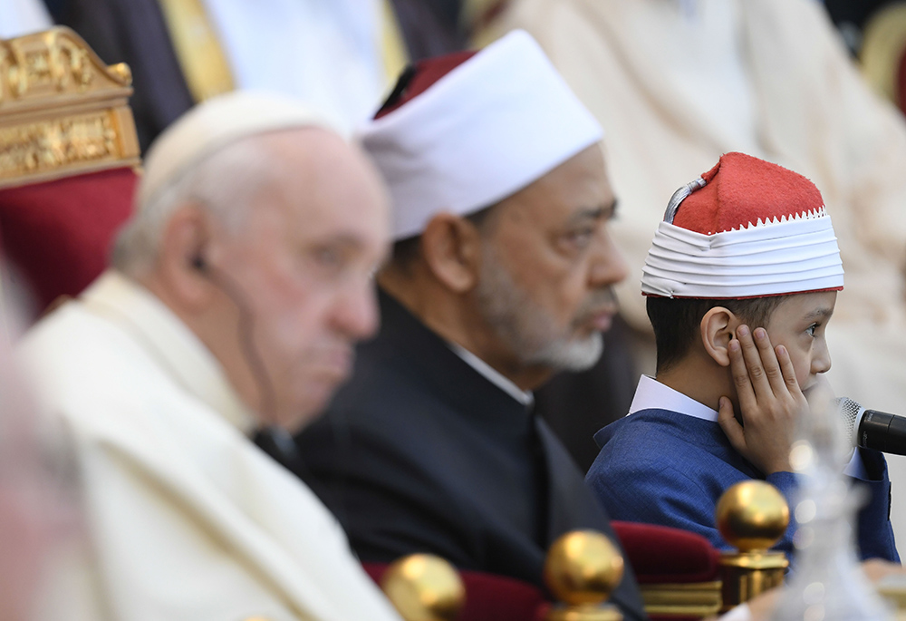 Pope Francis and Sheikh Ahmad el-Tayeb, grand imam of Egypt's Al-Azhar mosque and university, listen as a boy recites verses from the Quran during the popes meeting with members of the Muslim Council of Elders in the courtyard of the mosque at Sakhir Palace Nov. 4, 2022, in Awali, Bahrain. (CNS/Vatican Media)