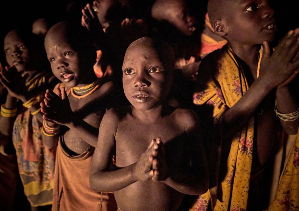 Photojournalist Paul Jeffrey took this photo of children praying and singing during an Oct. 21, 2021, prayer vigil for peace in Nakubase, a small village near Kuron in South Sudan's Eastern Equatoria state. (CNS/Paul Jeffrey)