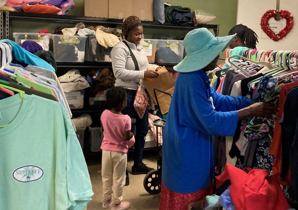 Woman selecting clothing at a donation center. 