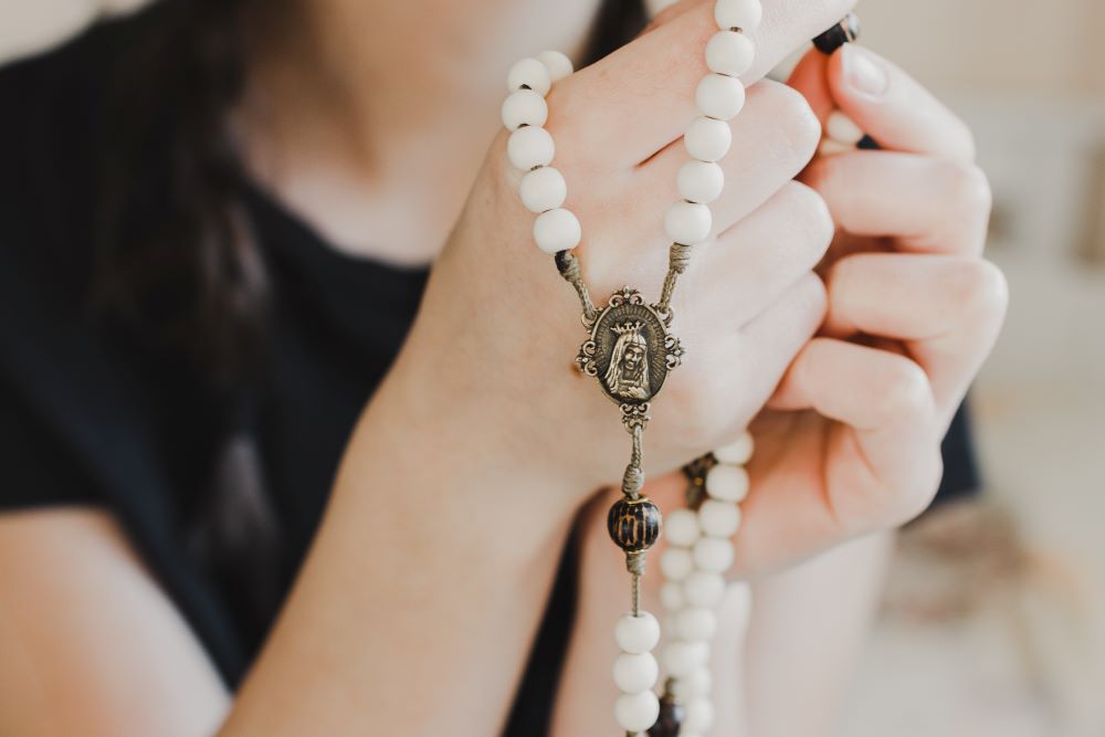 closeup of woman holding a rosary