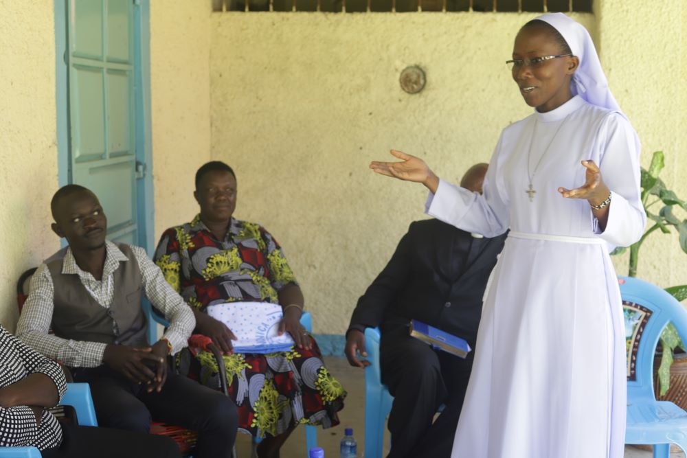 Nun stands and speaks to young people sitting in chairs.