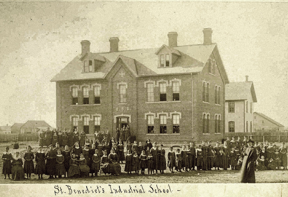 Students, sisters, and a priest pose before the newly reconstructed St. Benedict's Industrial School, an off-reservation boarding school for students from the White Earth Tribe in Minnesota, in 1886. ("Indian Girls Industrial School," College of Saint Benedict/Saint John's University Libraries, https://csbsjulib.omeka.net/items/show/915)