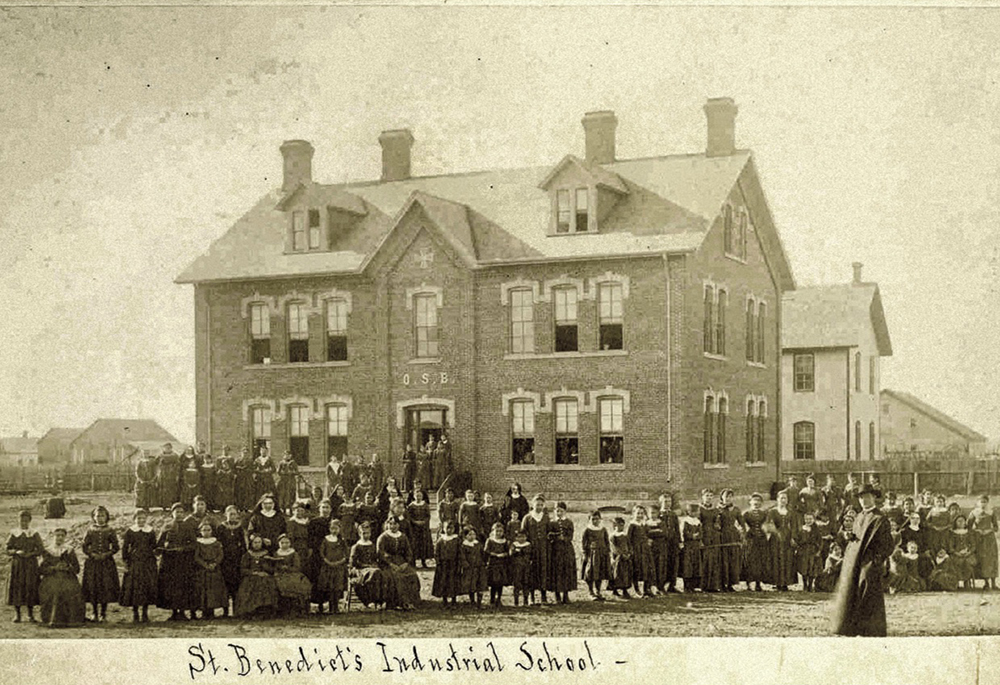 Students, sisters, and a priest pose before the newly reconstructed St. Benedict's Industrial School, an off-reservation boarding school for students from the White Earth Tribe in Minnesota, in 1886. ("Indian Girls Industrial School," College of Saint Benedict/Saint John's University Libraries, https://csbsjulib.omeka.net/items/show/915)