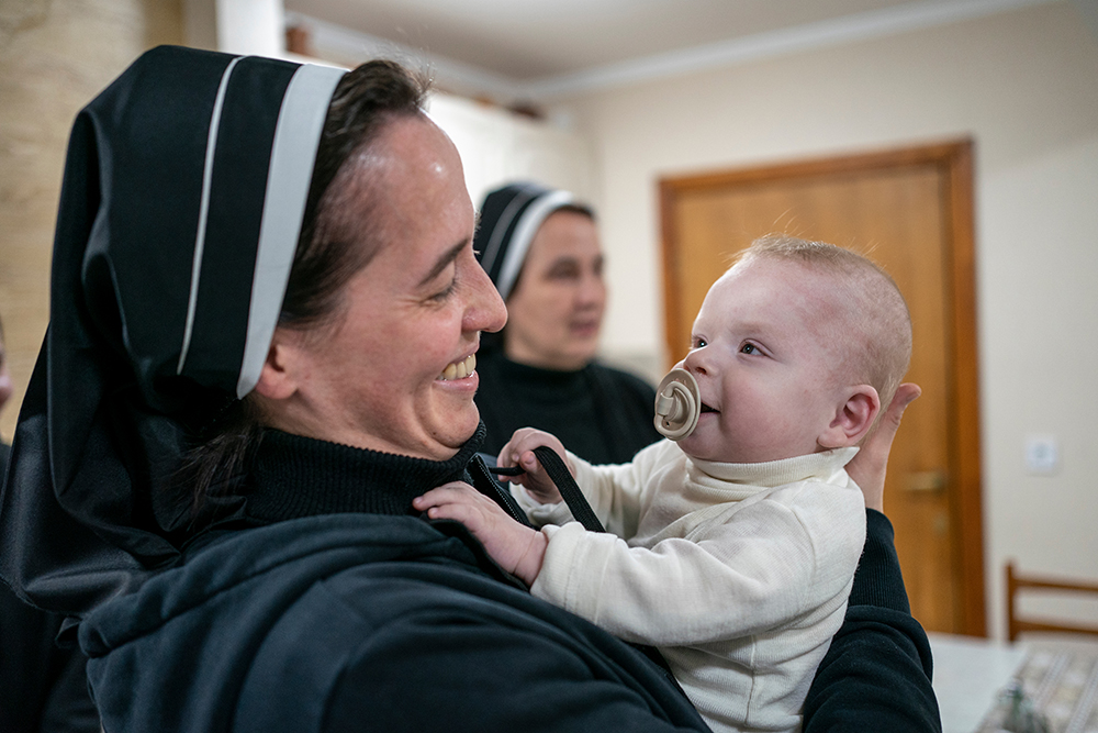 Sr. Veronika Yaniv of the Sisters Chatechists of St. Anne holds the son of one of the displaced mothers living at their convent. His mother was eight months pregnant when she arrived, and he has lived his entire life at the convent. (Gregg Brekke)