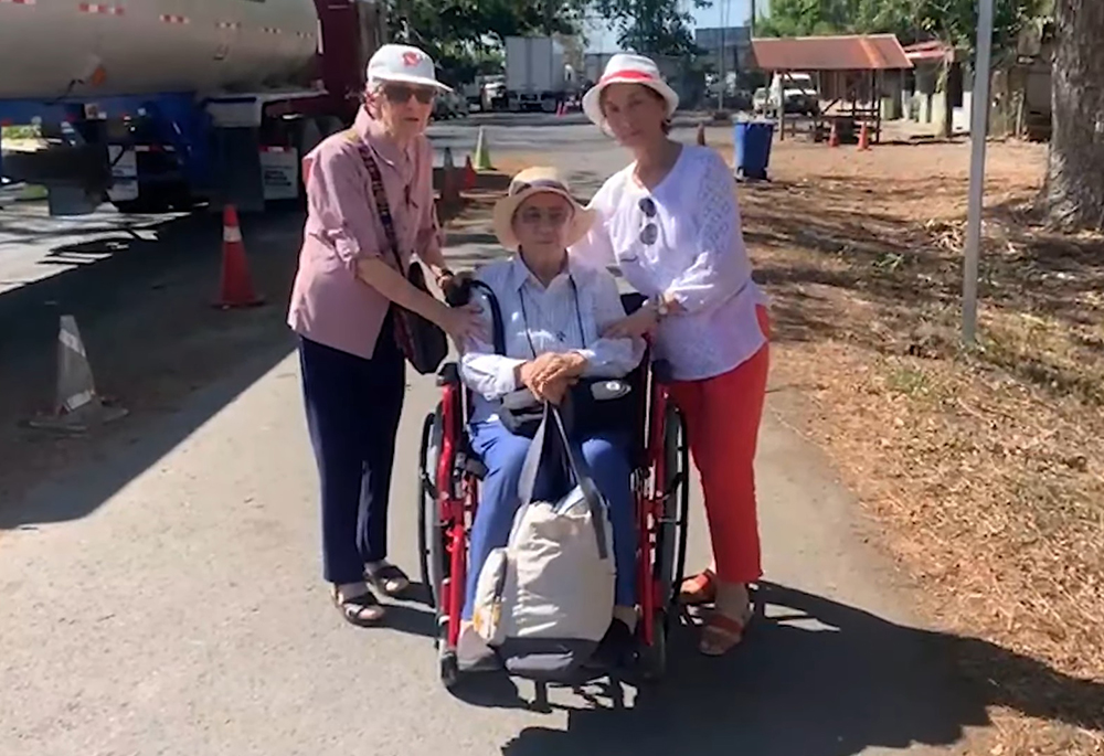 Dominican Sisters of the Anunciata Isabel Blanco, left, and Cecilia Blanco, in the wheelchair, are welcomed April 12 into Costa Rica by their biological sister Violeta Blanco after crossing from Nicaragua, in this video posted on Facebook by the Diocese of Tilarán-Liberia. (GSR screen capture/Facebook)
