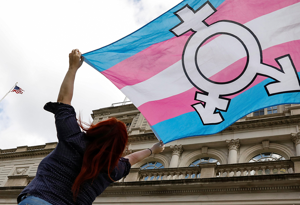 A person in New York City holds up a transgender flag Oct. 24, 2018. (CNS/Reuters/Brendan McDermid)