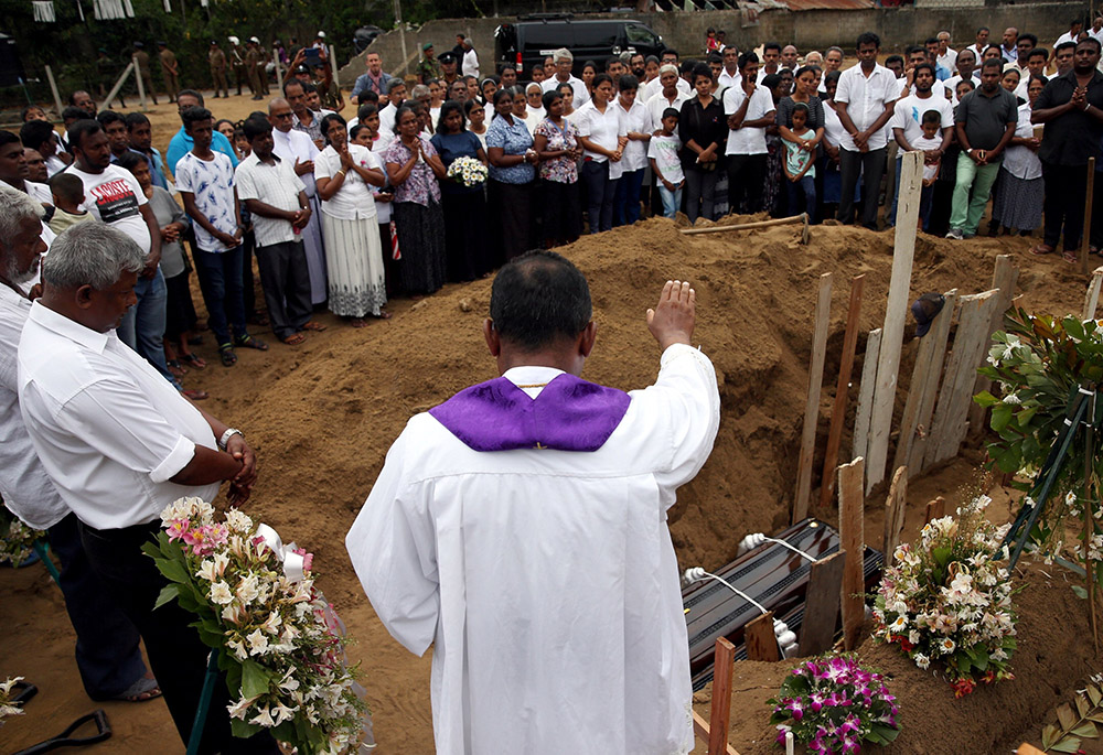 A clergyman prays over the casket of 13-year-old Dhami Brindya during her burial in Negombo, Sri Lanka, April 25, 2019, four days after suicide bomb attacks on churches and luxury hotels. (CNS/Reuters/Athit Perawongmetha)