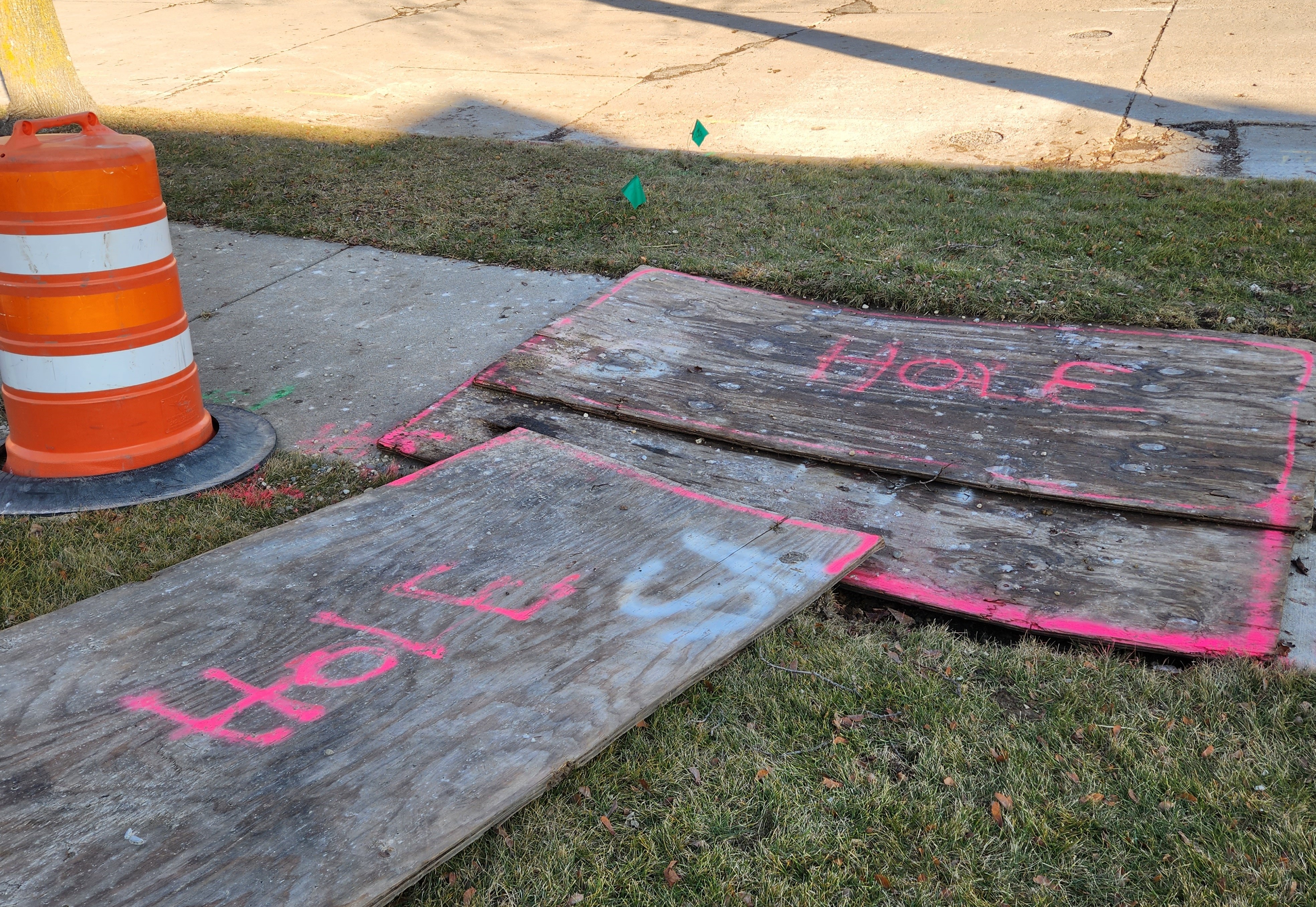 Pieces of wood marked "hole" cover spots where workers are repairing utility lines.