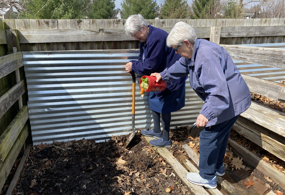 Srs. Marge Clifford and Judy Warmbold add the Daughters of Charity's weekly contributions to the parish compost garden, at Holy Spirit Parish in Maryland Heights, Missouri. In this edition of The Life, panelists discuss their actions to address the climate crisis. (Courtesy of Honora Remes)