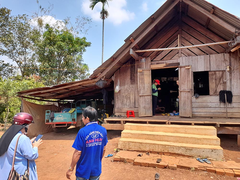 Mary Queen of Peace Sr. Teresa Nguyen Thi Bich visits Ay Phuong, an Ede villager who owns a traditional wooden house in Buon Drang, Vietnam. He has a grandson with hydrocephalus, and the nuns encourage his family to care for the boy patiently. (Joachim Pham)