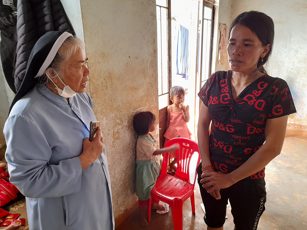 Mary Queen of Peace Sr. Teresa Nguyen Thi Bich consoles No Rek, age 40 with six children in Dak Lak province, Vietnam. One of her children has hydrocephalus and is bedridden, and her husband died of septicemia last October. She is a member of a lay association that Bich leads. (Joachim Pham)