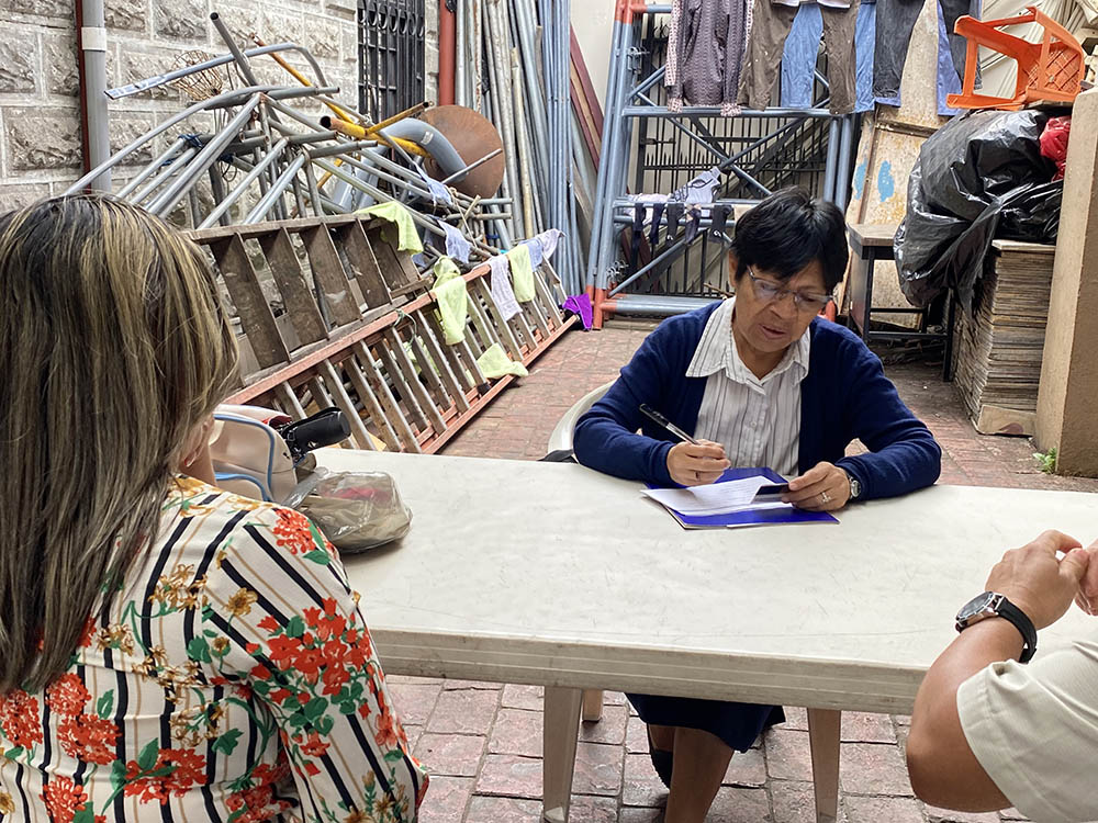 Scalabrinian Sr. María Angélica Tiralle helps a migrant couple fill out documents at the Church of Our Lady of Mercy in San José, Costa Rica, April 2. The charism of the religious order to which the sister belongs is focused in supporting migrants. (GSR Photo/Rhina Guidos)