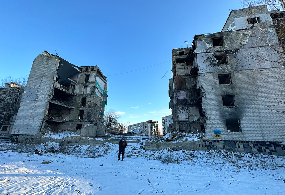 GSR's Chris Herlinger, in the center, walks near the center of an apartment complex in Borodyanka, Ukraine, which collapsed when it was hit by a Russian missile on April 5, 2022. (GSR photo/Gregg Brekke)