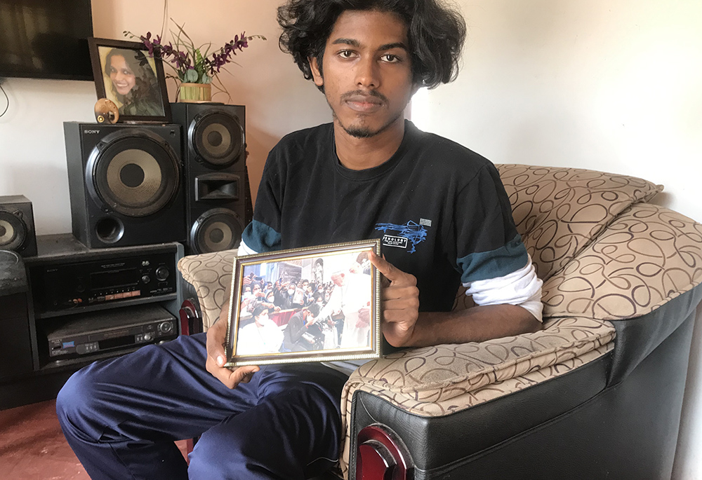 Hasaru Shenal survived the 2019 suicide bomb attack on St. Sebastian's Church but lost his mother, who did not survive. Shenal is pictured showing his photo with Pope Francis. (Thomas Scaria)