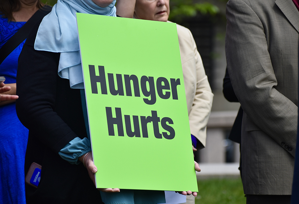 1 A participant at the "Care Not Cuts" rally holds a sign reading "Hunger hurts" April 26 in Washington. (Courtesy of Network Lobby/Catherine Gillette)