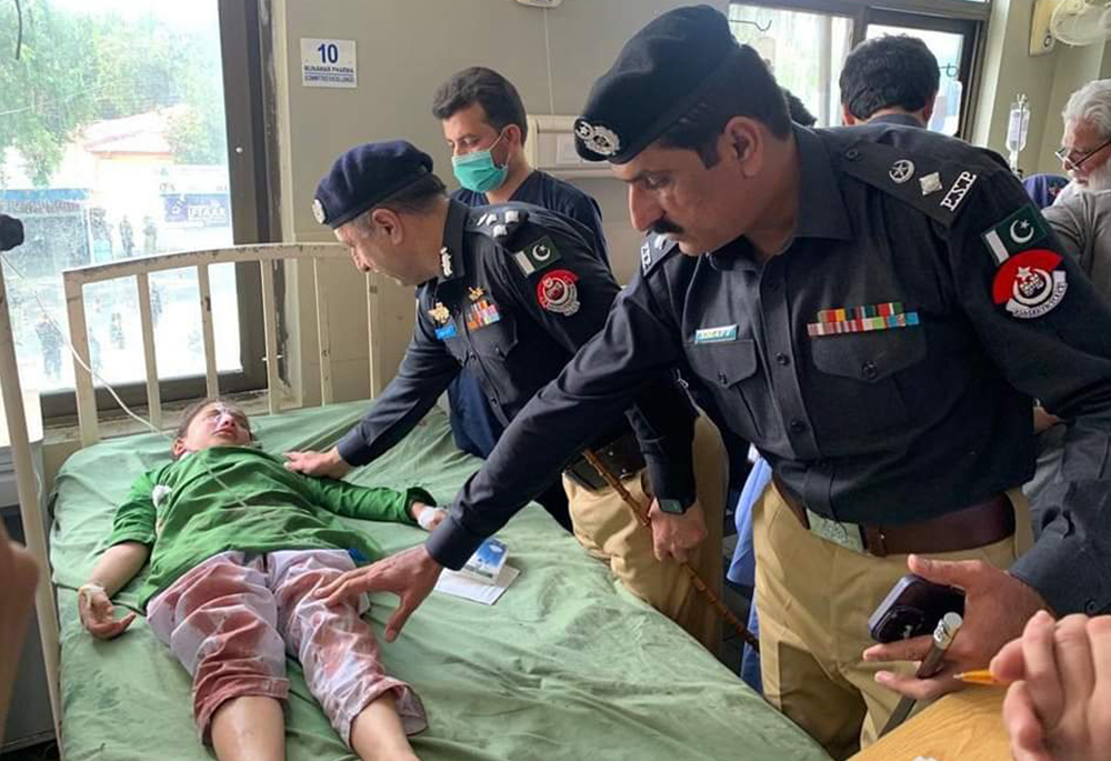 Swat Valley District Police Officer Shafiullah Gandapur, right, visits the students of Sangota Public School at a hospital on May 16. (Courtesy of Sr. Teresa Younas)